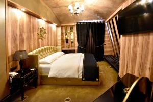 um quarto com uma cama e um lustre em Hotel Hymeti's Palace em Pogradec