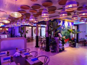 a restaurant with purple lighting and tables and chairs at FORTUNE ATRIUM HOTEL in Dubai