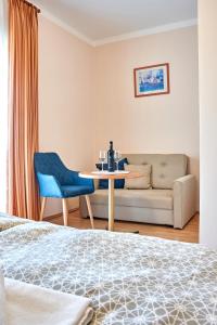 1 dormitorio con cama, mesa y sofá en Vojtek Pince Vendégház, en Villány