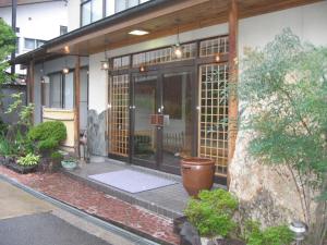 un ingresso a un edificio con una grande porta a vetri di Yudanaka Yasuragi a Yamanouchi