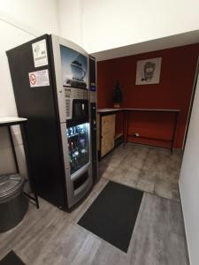 Zimmer mit einem großen Kühlschrank und einem Tisch in der Unterkunft Airport Boulevard Guesthouse in Grassobbio