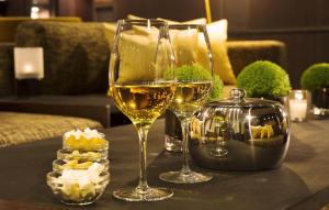 Hotel Villa Saxe Eiffel في باريس: كأسين من النبيذ الأبيض يجلسون على الطاولة