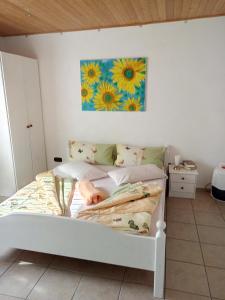 a white bed in a bedroom with a painting on the wall at Villa Behija Ferienwohnung 2 Crikvenica in Crikvenica