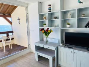 un soggiorno con TV e vaso di fiori di BRITANNIA - Studio tout équipé, Vue mer - U95 a Carnac