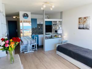 una camera da letto con un letto e un tavolo con un vaso di fiori di BRITANNIA - Studio tout équipé, Vue mer - U95 a Carnac