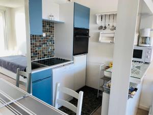 una piccola cucina con armadi blu e piano cottura di BRITANNIA - Studio tout équipé, Vue mer - U95 a Carnac Altre 5 foto