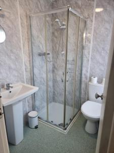 a bathroom with a shower and a toilet and a sink at Hotel Vienna in Blackpool