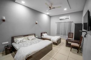 1 dormitorio con 2 camas y TV. en RESORT GOLDEN CAVE, en Jodhpur