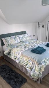 uma cama com um cobertor e almofadas em Cosy 2 Bedroom Coach House em Belfast