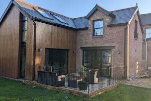 una casa in mattoni con tetto nero di Cosy 2 Bedroom Coach House a Belfast