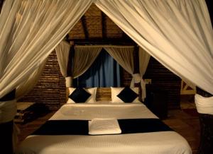 1 dormitorio con cama con dosel y cortinas blancas en Farm Stay Resort - Shamirpet, Hyderabad, en Hyderabad