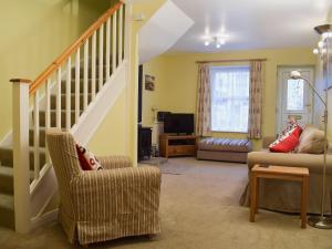 a living room with a staircase and a couch at Buckingham Cottage in Ventnor