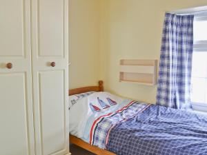 a small bedroom with a bed and a window at Buckingham Cottage in Ventnor