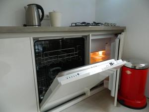 an oven with its door open in a kitchen at Modern en sfeervol appartement aan zee met airco in Zoutelande
