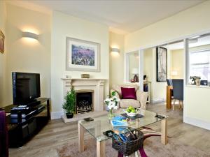 a living room with a fireplace and a tv at Cornerstone in Castletown