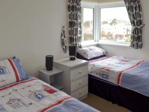 a bedroom with two beds and a window at Rosehill in Goodrington