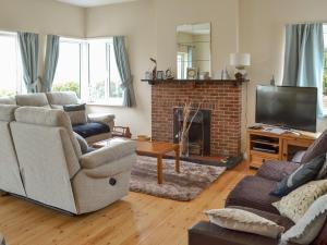 a living room with two couches and a fireplace at Rosehill in Goodrington