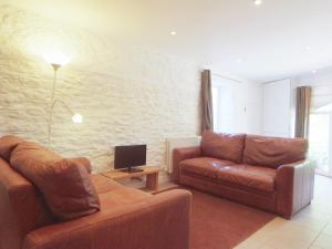 a living room with two leather couches and a television at Dandelion Cottage - 28151 in Totnes