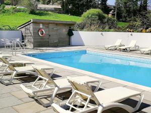 a group of chairs and a swimming pool at Dandelion Cottage - 28151 in Totnes