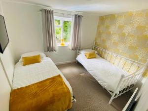 a bedroom with two beds and a window at The Old Toll House in Coalport