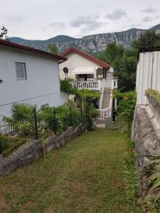 uma casa branca com uma cerca e um quintal em Villa Behija Ferienwohnung 1 Cikvenica em Crikvenica