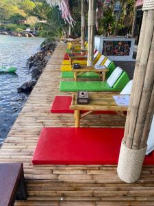 una fila de mesas con alfombras coloridas en un muelle en Phi Phi Green House & Sunsky Hostel en Islas Phi Phi