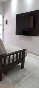 sala de estar con sofá y TV de pantalla plana en Chañar y Algarroba en Cafayate