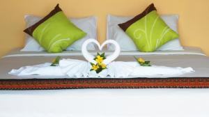 łóżko z dwoma ręcznikami w kształcie serca w obiekcie KOHMOOK THE SUN GREAT RESORT w mieście Ko Mook