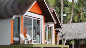 a house with white chairs on a porch at KOHMOOK THE SUN GREAT RESORT in Koh Mook