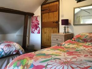 a bedroom with two beds and a mirror at The Coach House in Falkenham