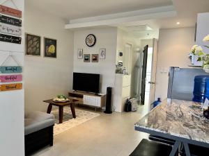 sala de estar con TV de pantalla plana y mesa en Elaiza's Cozy Home - Matina Enclaves Building C Unit 815, en Davao City