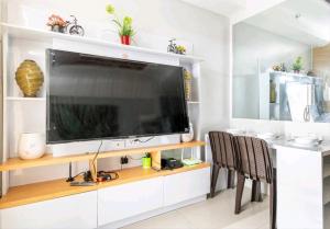 uma sala de estar com uma grande televisão de ecrã plano em Grass Residences SM North Edsa and Trinoma em Manilla