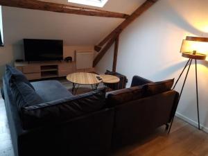 a living room with a couch and a table at Appartement Little Stuart in Dol-de-Bretagne