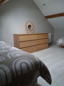 een slaapkamer met een bed en een dressoir met een spiegel bij Appartement Little Stuart in Dol-de-Bretagne