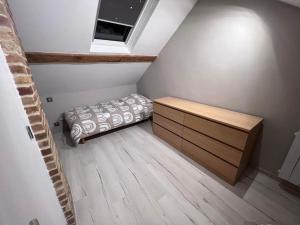 een kleine slaapkamer met een bed en een dressoir bij Appartement Little Stuart in Dol-de-Bretagne