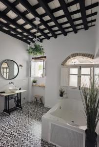 a bathroom with a tub and a table and a mirror at Casa del Sacramento - CASITA CON ENCANTO in Medina Sidonia
