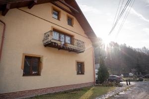 a building with a balcony on the side of it at Penzión DolinkaGápel in Valaská Belá