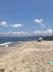 a sandy beach with umbrellas and the ocean at Il Nido di Mortelle II in Messina