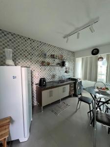 a kitchen with a refrigerator and a table with chairs at Apartamento 2 Bairro Boa Vista 1 in Caruaru
