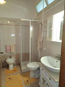 a bathroom with a toilet and a sink and a shower at Il Nido di Mortelle II in Messina