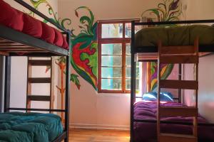 um quarto com beliches e um mural colorido na parede em Hostal Po em Valparaíso