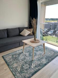 a living room with a couch and a coffee table at PUŠIS IR JŪRA - Mano Jūra 2 complex - Kunigiškiai in Palanga