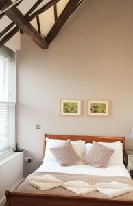 een bed met witte lakens en kussens in een slaapkamer bij Riverside Stamford Stays in Stamford