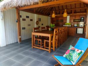 a dining room with a table and chairs on a patio at Little Lodge in Gili Trawangan