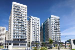 three tall buildings in a city with cars in front at Itaguaí Flat Executivo - Centro in Itaguaí