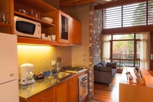 cocina con fregadero y microondas en Amonite Apart & Spa en San Martín de los Andes