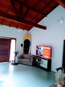 sala de estar con sofá y TV de pantalla plana en Casa praia bombinhas 150m mar, en Bombinhas