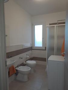 a bathroom with a toilet and a sink and a window at Casa Istadi in Maracalagonis