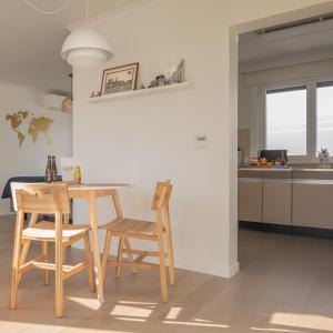 uma cozinha com uma mesa de madeira e 2 cadeiras em Gasthuis 20 verdiep 2 em Kuurne