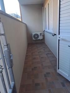 an empty room with a hallway with a window and a fan at Casa Istadi in Maracalagonis